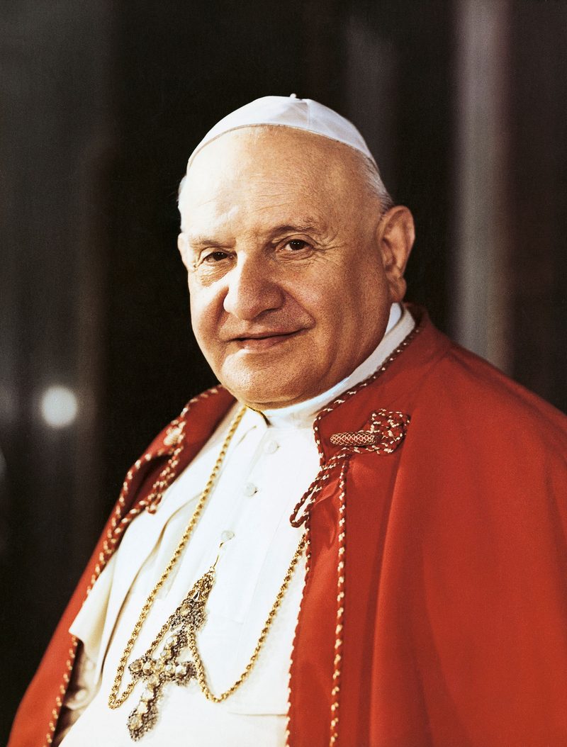 A colour photograph of Pope St John XXIII smiling, in red mozzetta and stole.