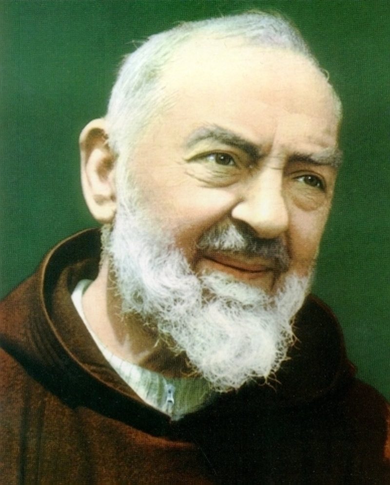 A colour portrait of Padre Pio: an elderly Capuchin friar with a white beard and a warm, steady gaze.