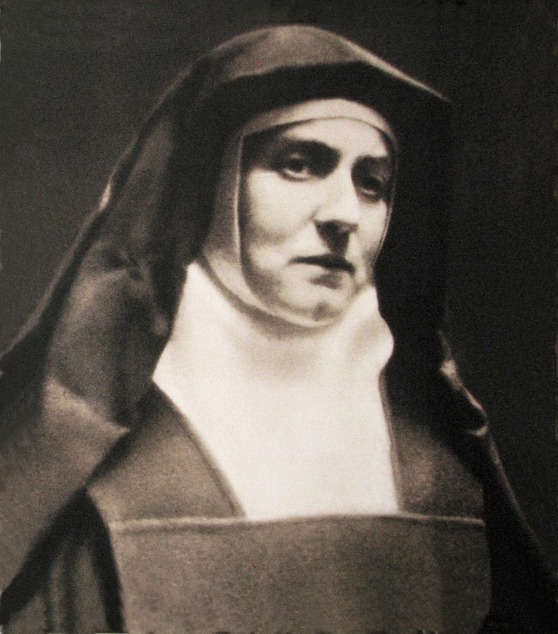 A photograph of Edith Stein as a Carmelite nun, about 1938: a woman in a dark veil and white wimple, looking calmly at the camera.