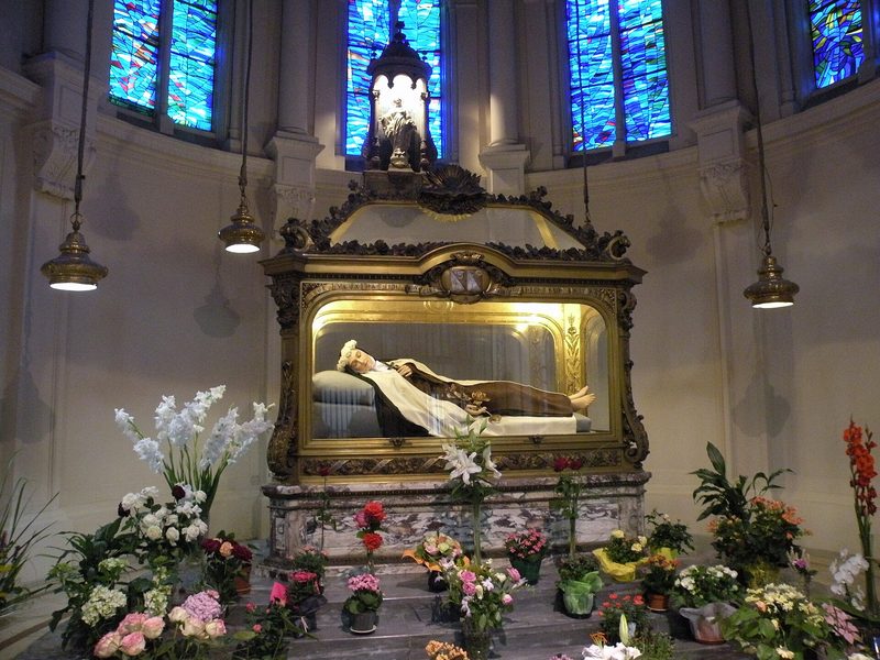 The chapel of the Carmel of Lisieux: a statue of St Thérèse lies in a shrine surrounded by flowers and candles.